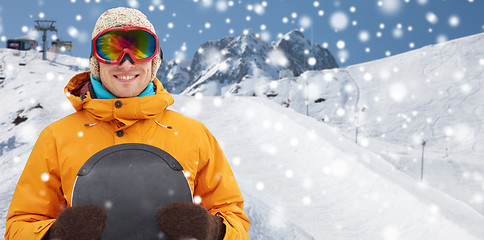 Image showing happy young man in ski goggles over mountains