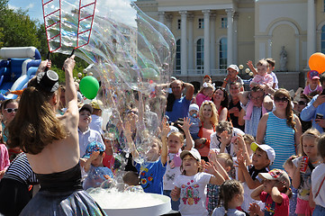 Image showing Happy children catch soap bubbles on the street