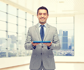 Image showing happy businessman in suit holding tablet pc