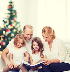 Image showing happy family with book at home