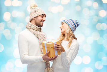 Image showing smiling couple in winter clothes with gift box