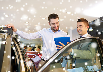 Image showing happy man with car dealer in auto show or salon