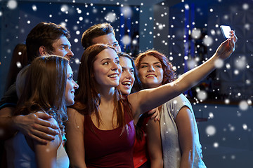 Image showing friends with smartphone taking selfie in club