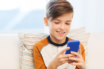 Image showing boy with smartphone texting or playing at home