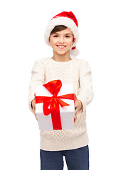 Image showing smiling happy boy in santa hat with gift box