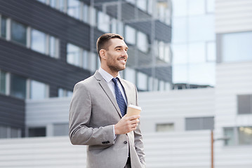 Image showing young serious businessman with paper cup outdoors