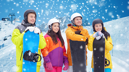 Image showing happy friends with snowboards over mountains