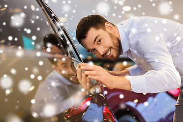 Image showing happy man touching car in auto show or salon