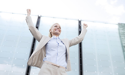 Image showing young smiling businesswoman over office building