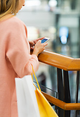 Image showing close up of woman with smartphone and shopping bag