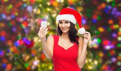 Image showing woman in santa hat taking selfie by smartphone