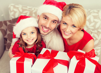 Image showing smiling family holding many gift boxes