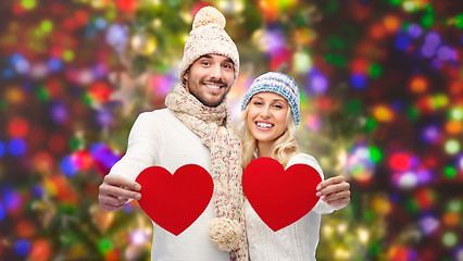 Image showing smiling couple in winter clothes with red hearts