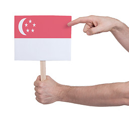 Image showing Hand holding small card - Flag of Singapore