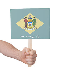 Image showing Hand holding small card - Flag of Delaware