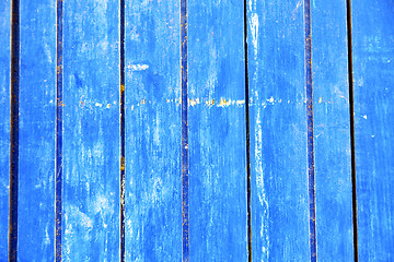 Image showing stripped  in the blue door and rusty nail