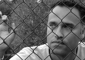 Image showing Man behind a fence