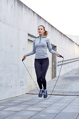 Image showing woman exercising with jump-rope outdoors
