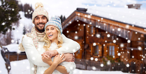 Image showing smiling couple in winter clothes hugging outdoors