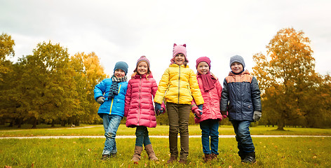 Image showing happy children holding hands in autumn park