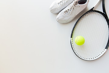 Image showing close up of tennis racket with ball and sneakers