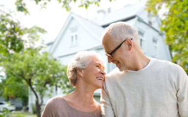 Image showing senior couple hugging over living house background