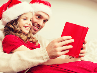 Image showing smiling father and daughter reading book