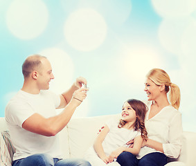 Image showing happy family with camera at home