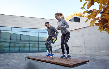 Image showing man and woman exercising on bench outdoors