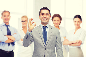 Image showing happy businessman in suit showing ok hand sign