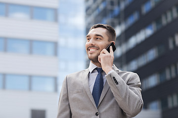 Image showing smiling businessman with smartphone outdoors