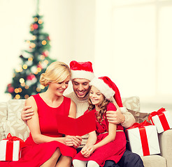 Image showing smiling family reading postcard