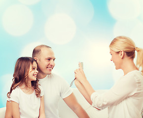 Image showing happy family with camera at home