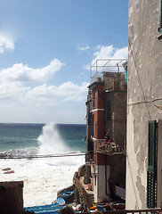 Image showing Riomaggiore Cinque Terre Italy waves breaking against historic h