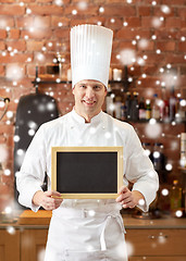 Image showing happy male chef with blank menu board in kitchen