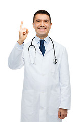 Image showing happy male doctor in white coat pointing finger up