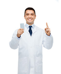 Image showing smiling male doctor in white coat with tablets