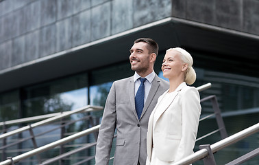 Image showing smiling businessmen standing over office building