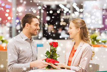 Image showing happy couple with present and flowers in mall