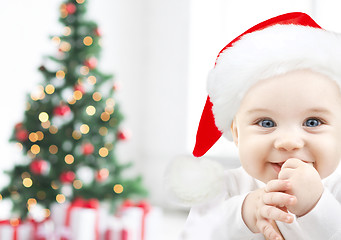 Image showing happy baby in santa hat over christmas tree lights