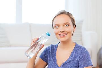 Image showing happy woman with water bottle at home