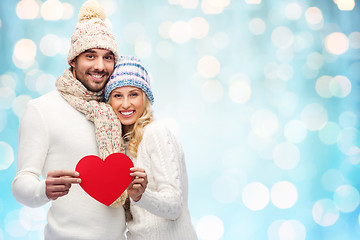 Image showing smiling couple in winter clothes with red hearts