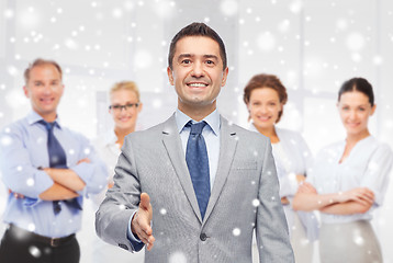 Image showing happy smiling businessman in suit shaking hand