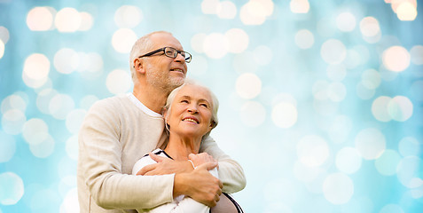 Image showing happy senior couple over blue holidays lights