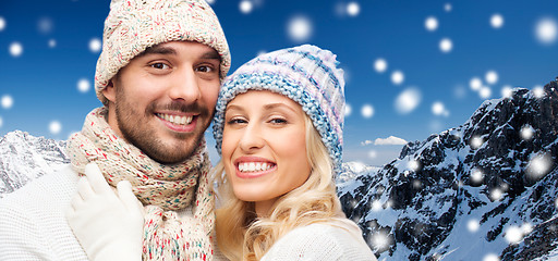 Image showing smiling couple in winter clothes over mountains