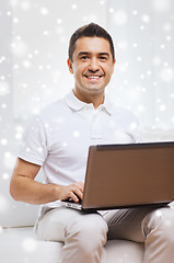 Image showing happy man working with laptop computer at home