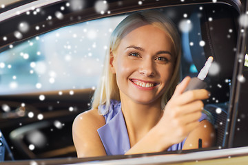 Image showing happy woman getting car key in auto show or salon