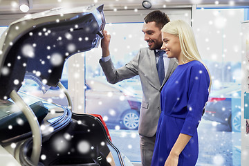 Image showing happy couple with car dealer in auto show or salon