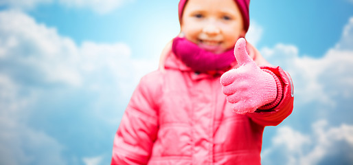 Image showing happy girl showing thumbs up over blue sky