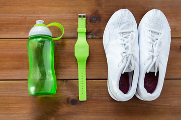 Image showing close up of sneakers, bracelet and water bottle